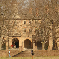 People walk in the Sunken Garden during a fall day with the Wren Building in the background
