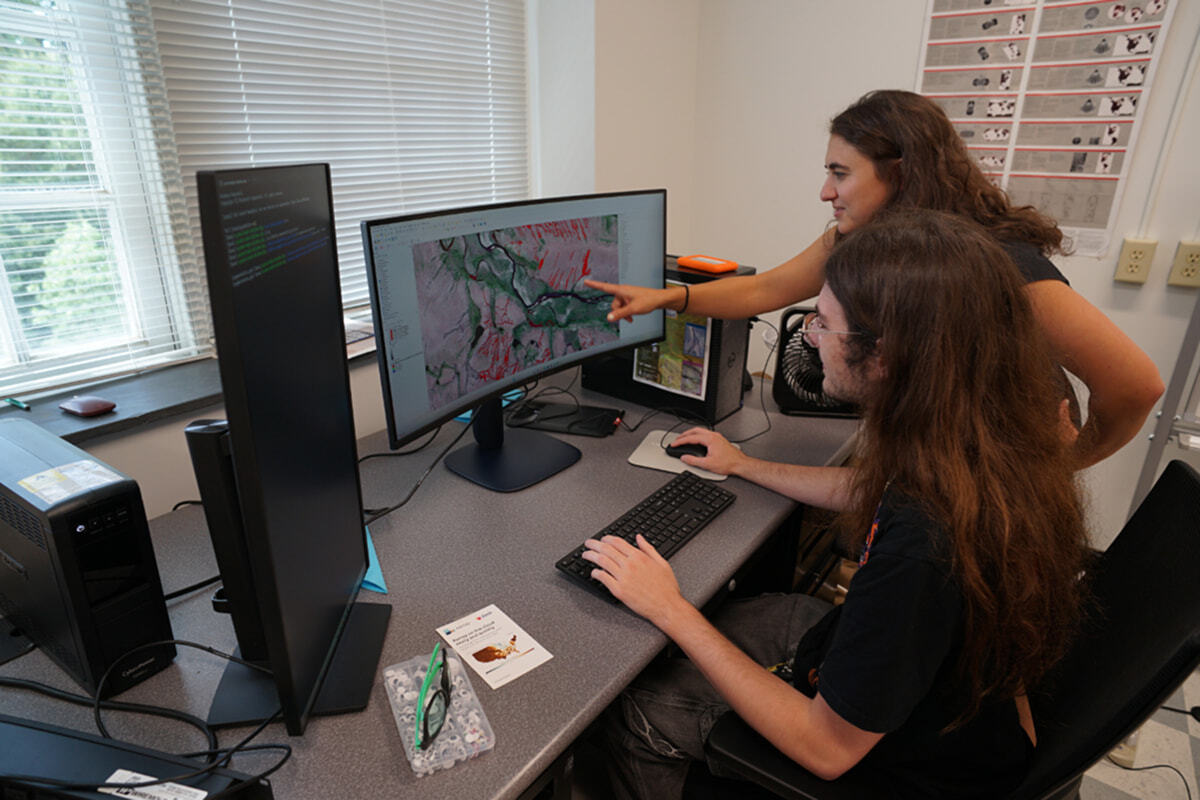 Gabriel Imholte ‘28 reviewing his geology research on a computer alongside his research advisor Joanmarie Del Vecchio.
