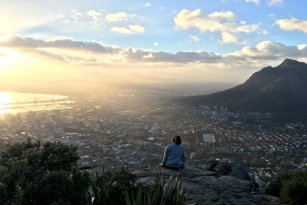 student sitting at the top of a mountain in Capetown