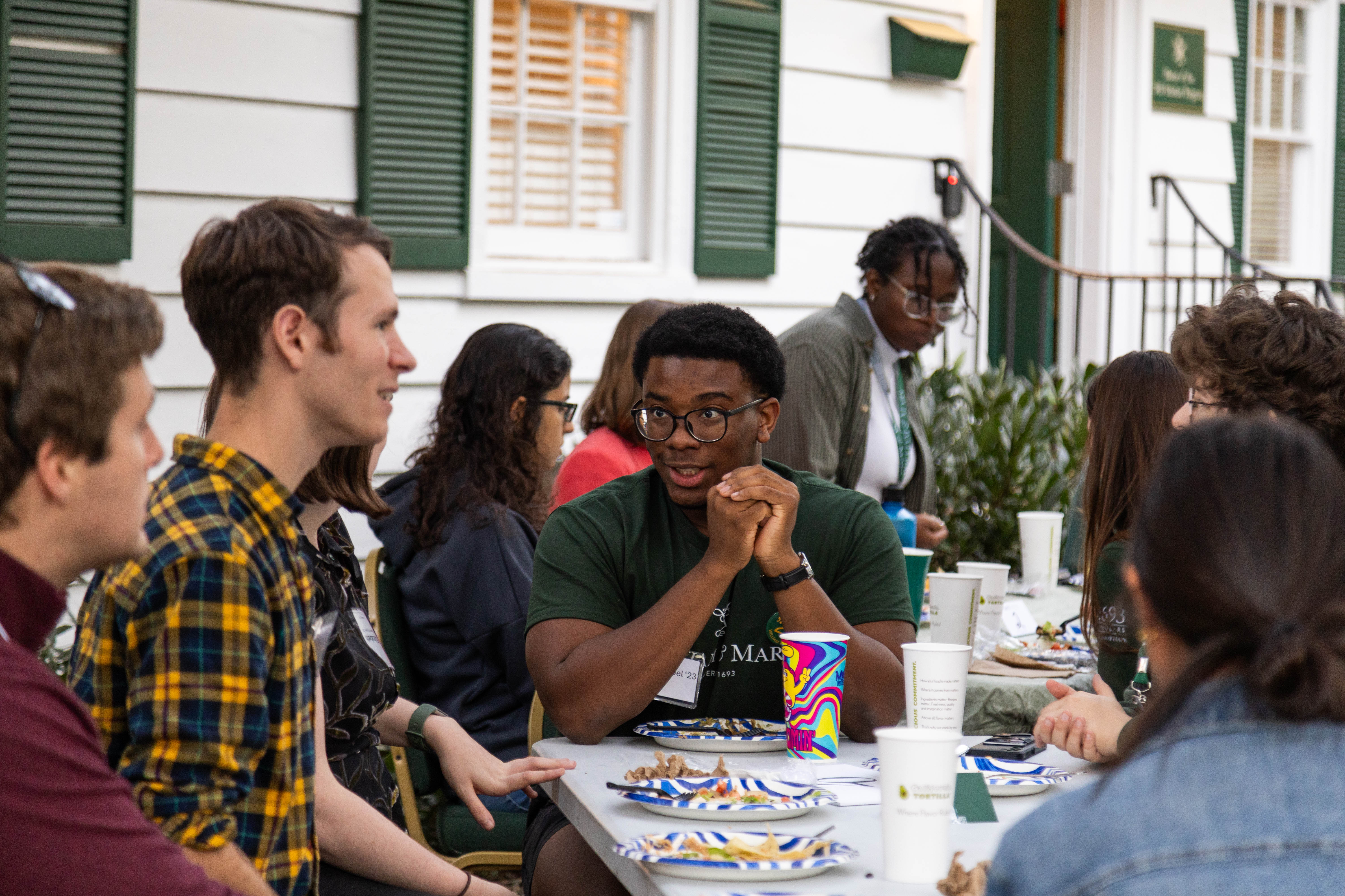 Carlos Noel '23 (center) enjoys a Homecoming reunion meal on the Murray House lawn, reminiscent of the regular lunches with guest speakers that occur nearly every Friday throughout the academic year. (Photo by Tess Willett)