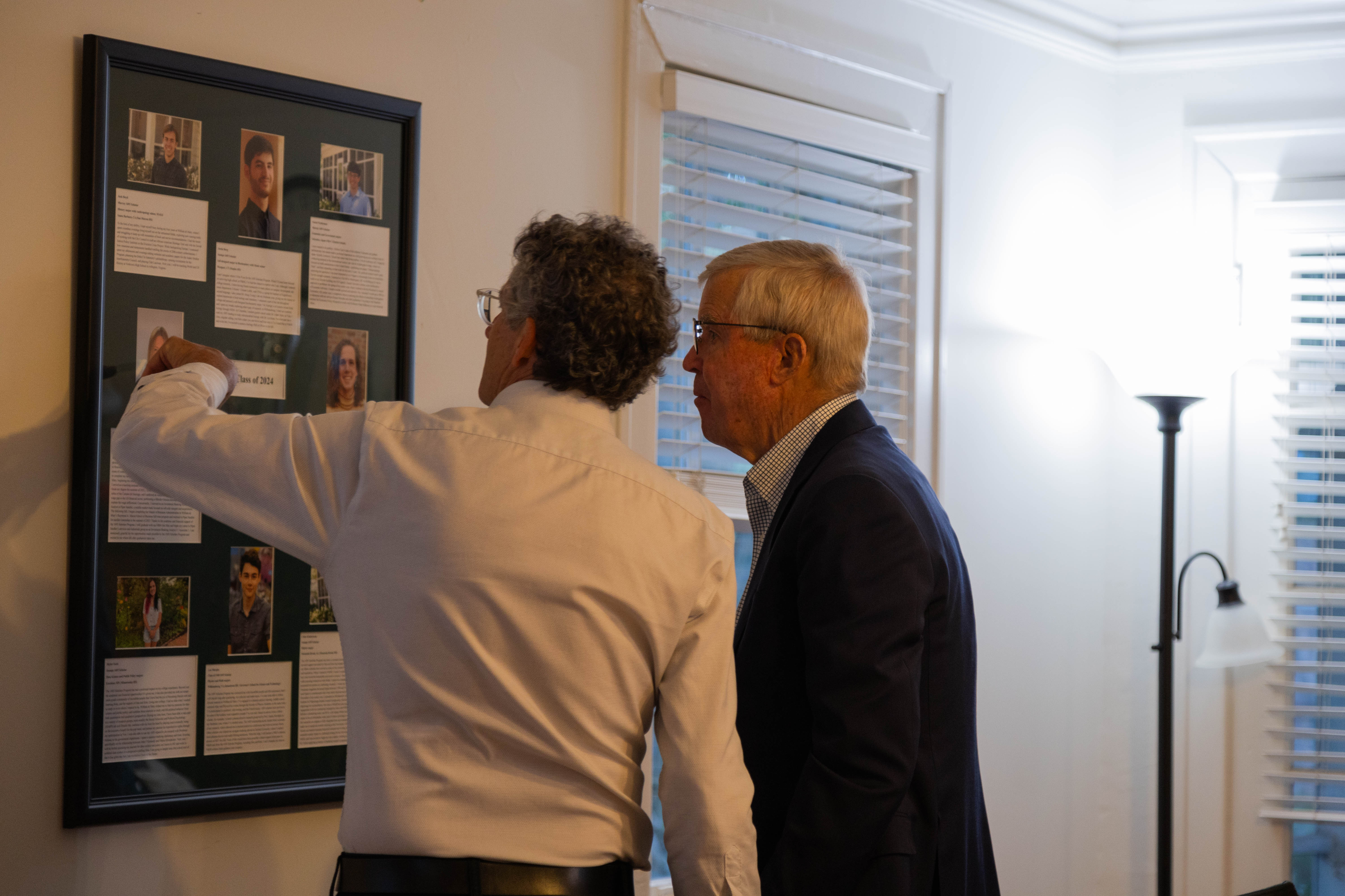 1693 Director Dan Cristol (left) and James B. Murray Jr. share a quiet moment during last month's Homecoming celebration to appreciate the nearly 100 portraits and biographies of 1693 alums on display in Murray House. (Photo by Tess Willett)