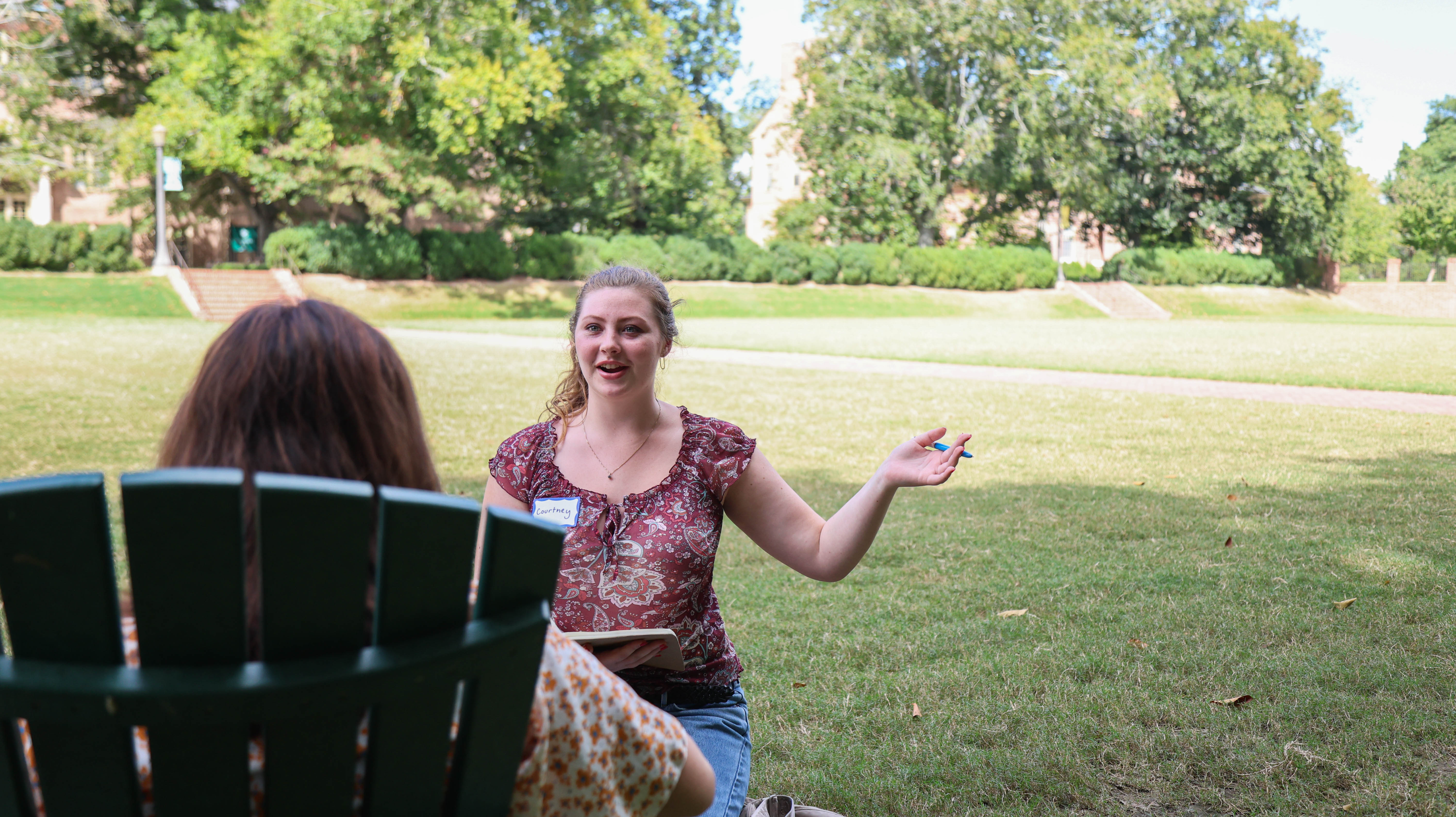 Environmental humanities and public policy major Courtney Hand '25 interviewed a student on W&M's sunken garden Sept. 6, as part of a masterclass assignment on interviewing and reporting. (Photo by Tess Willett)