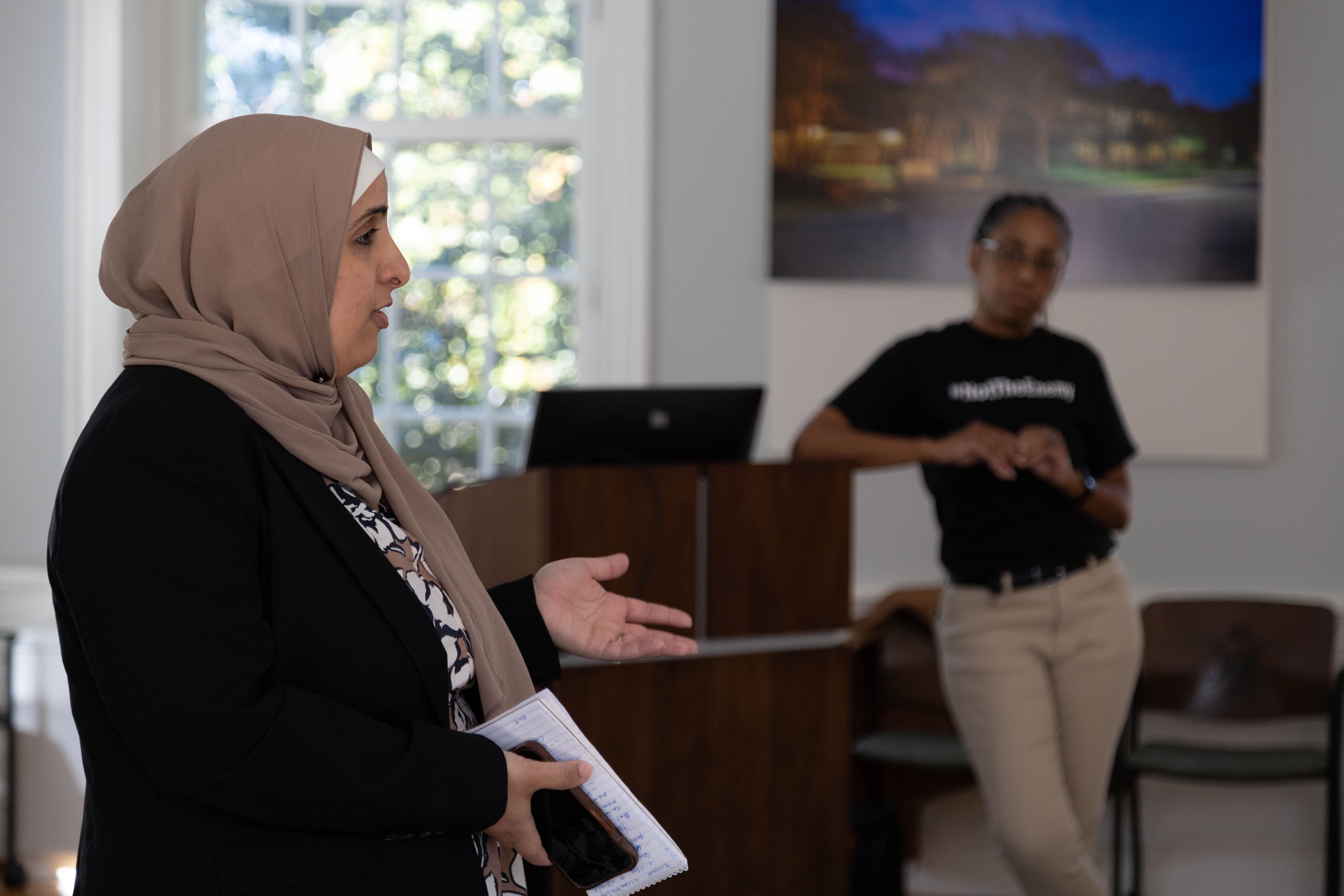 Nour Habib (left), who covers education for the Virginia-Pilot and Daily Press newspapers, draws attention to headlines and the ethics of word choice in the Oct. 25 masterclass led by Denise Watson (right). (Photo by Tess Willett)