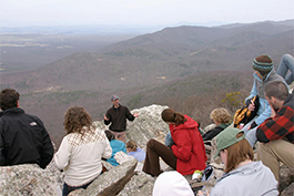 On top of Turk Mountain in the Blue Ridge, Greg Hancock, associate professor of geology, talks to students about erosion on the annual senior geology field trip.