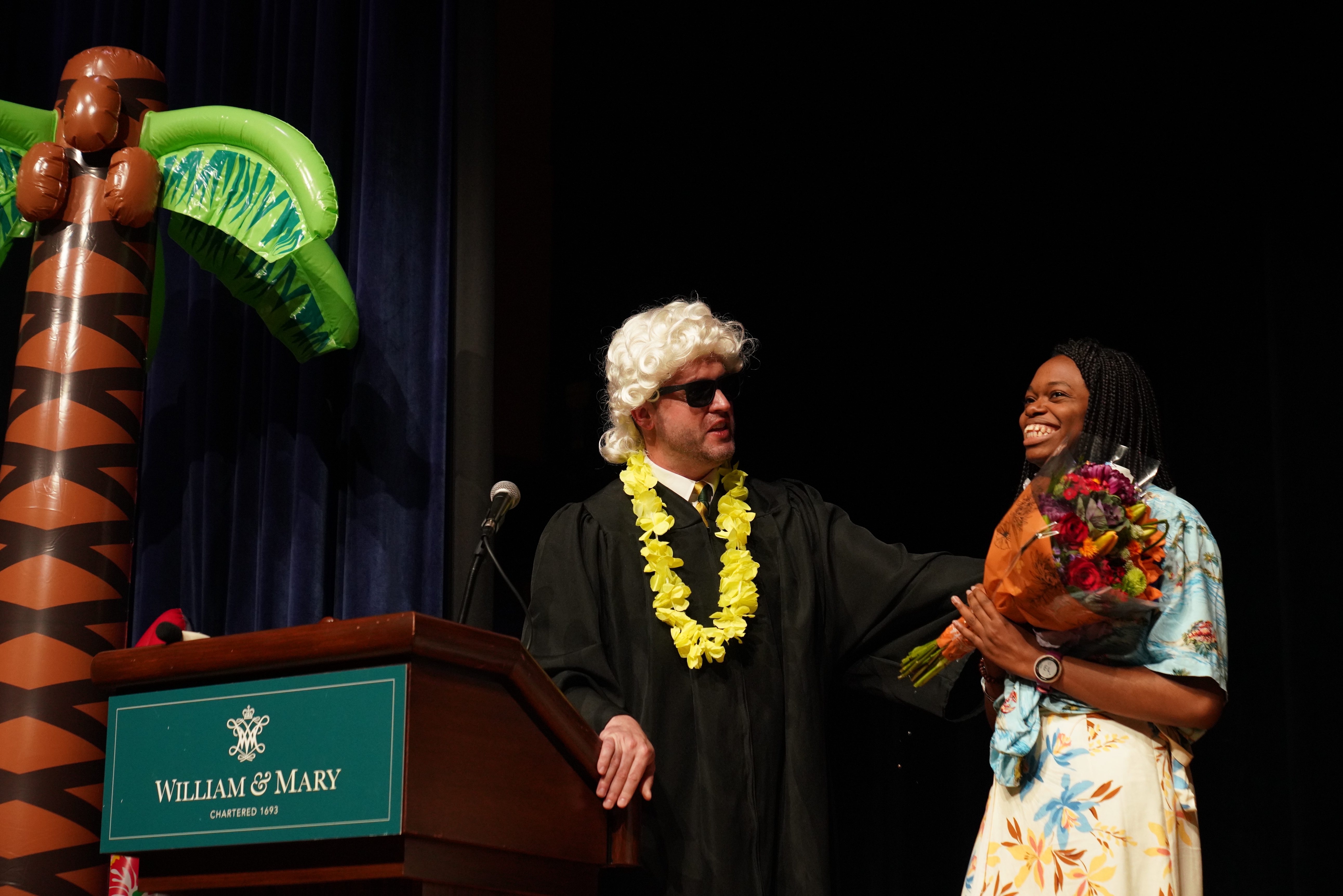 Raft Debate emcee, Assistant Dean for Graduate Studies, Trey Mayo, presents Ukamaka Ozed-Williams '25 with flowers (Photo by Steven Salpukas)