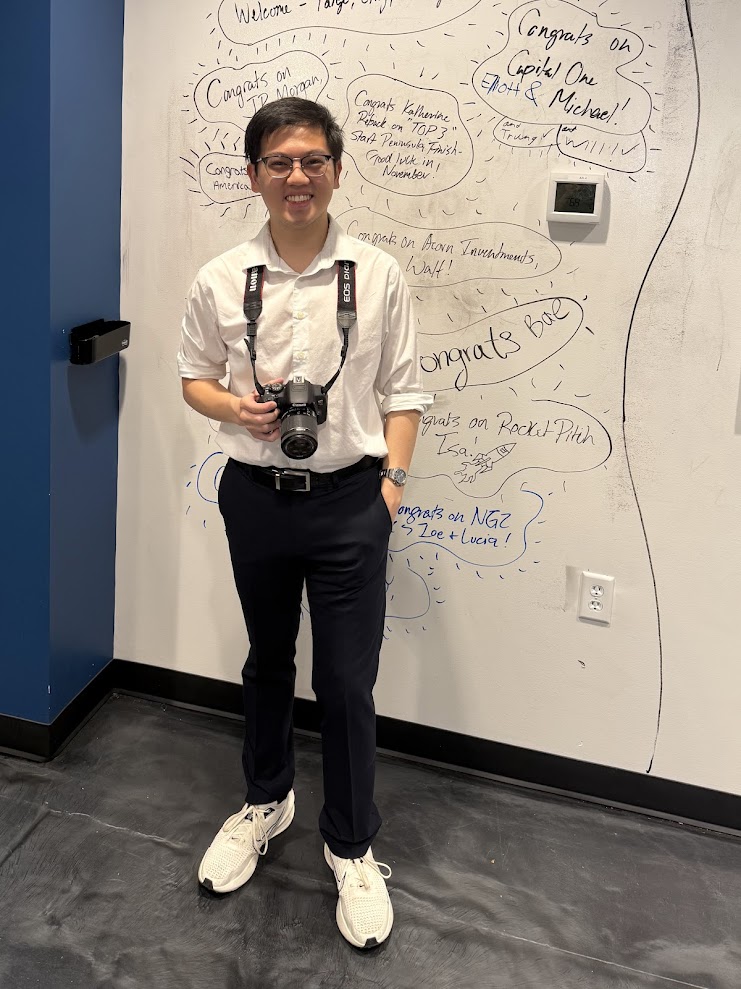 A photo of Jason Zheng holding a camera