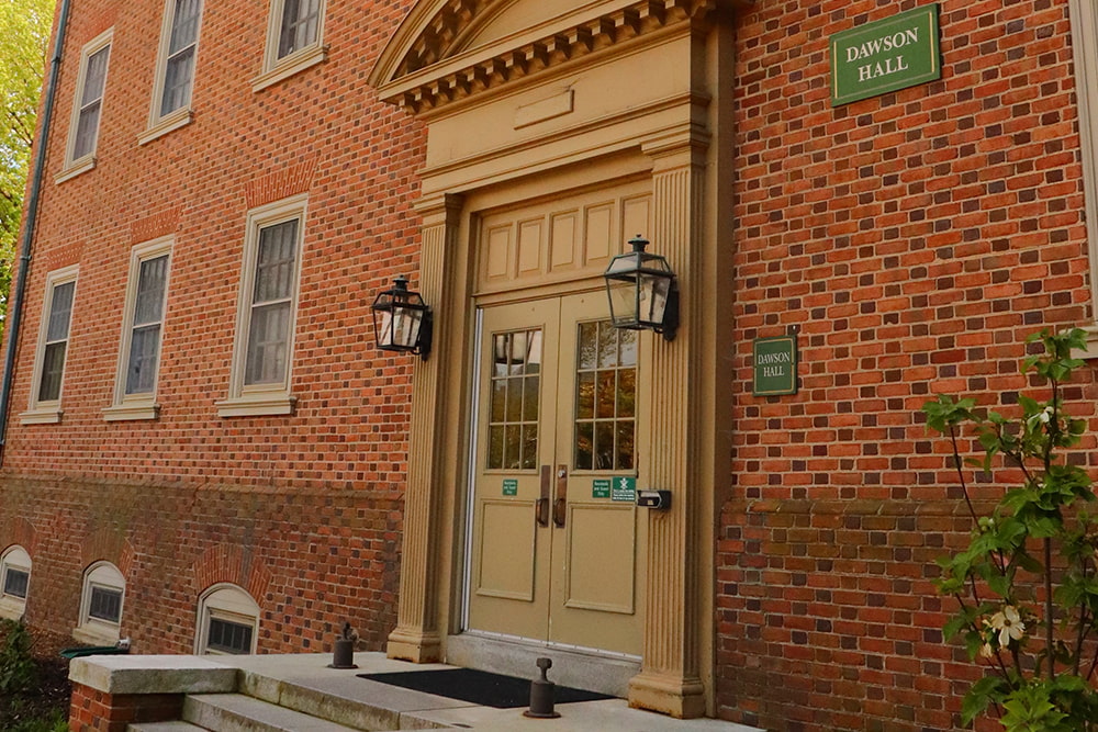 The entrance to a brick, windowed dorm building.