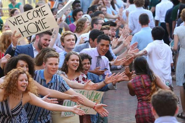 Students energetically cheering to celebrate new students as they process through the Wren Courtyard