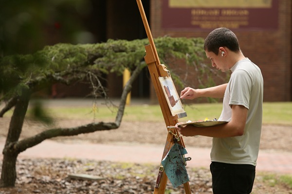 student_painting_looking_left_outdoors