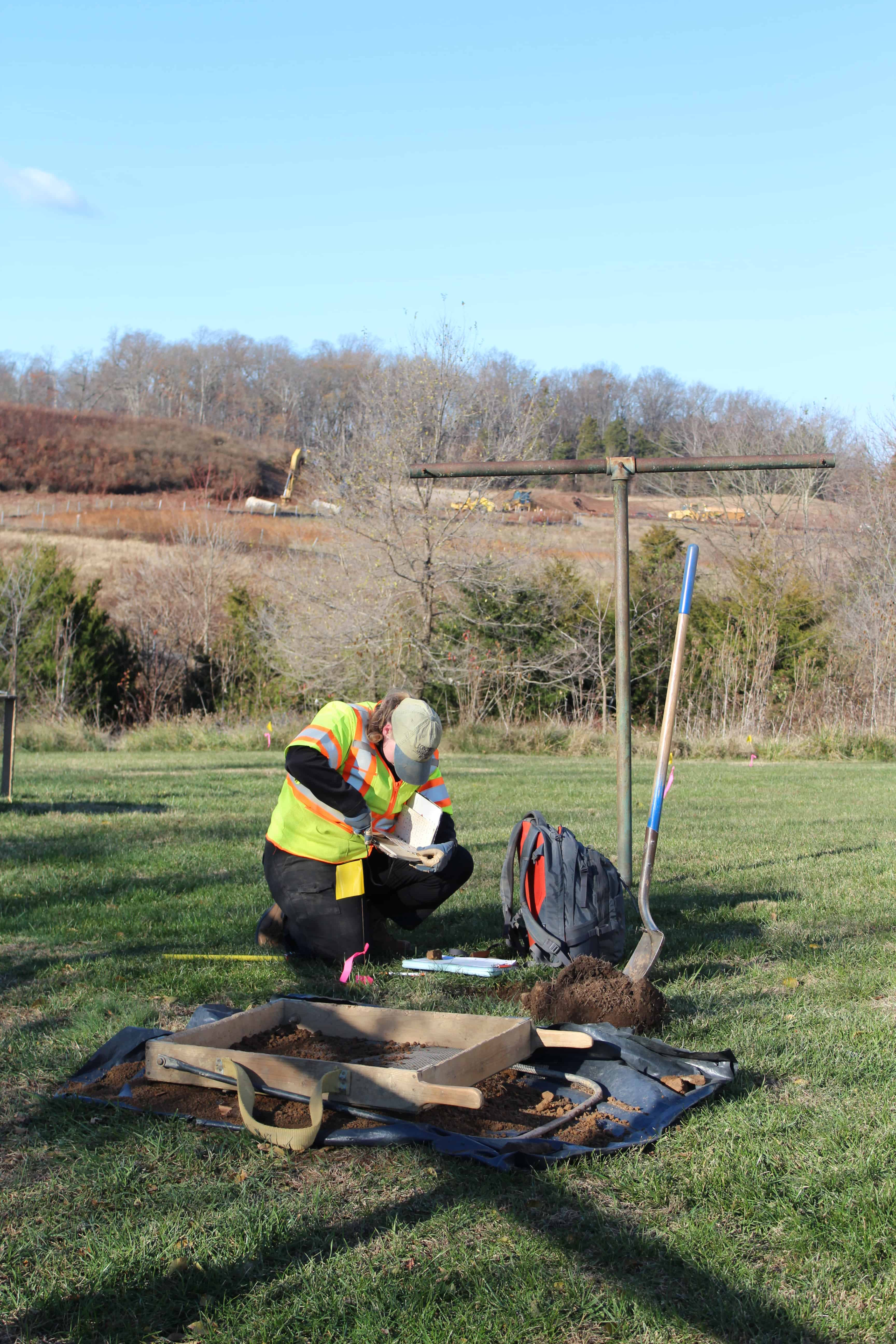 An archaeologist documents the characteristics of soil from a shovel test excavated at the Arcola Quarters for the Enslaved in Loudoun County, Virginia